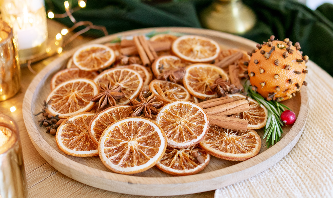 Close up van sinaasappelschijven kaneelstokjes steranijs en kruidnagels op een houten plank