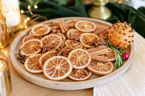 Close up van sinaasappelschijven kaneelstokjes steranijs en kruidnagels op een houten plank