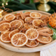 Close up van sinaasappelschijven kaneelstokjes steranijs en kruidnagels op een houten plank