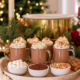 Glazen mokken warme chocolademelk met slagroom naast bakjes met marshmallows hagelslag en spikkels