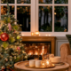 Close up van een gebogen kerstboomtop met een grote rode kerstbal en groene veren tussen de takken